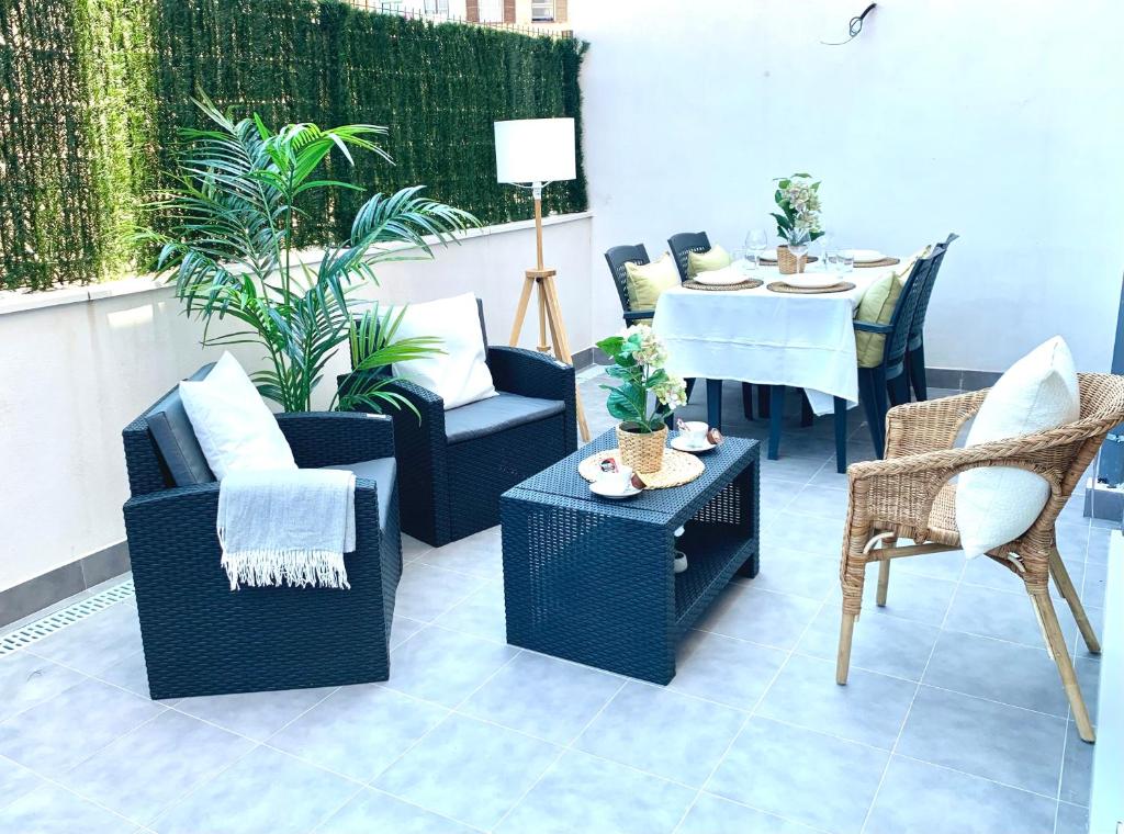 a patio with wicker chairs and a table and chairs at Nuevo Apto A Centrico Terraza Garaje Incluido in Castro-Urdiales