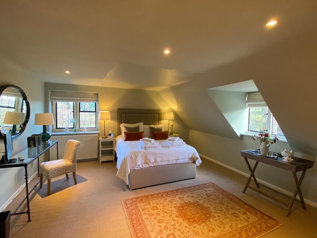 Mill Hay Country House في برودواي: غرفة نوم بسرير وطاولة وكرسي