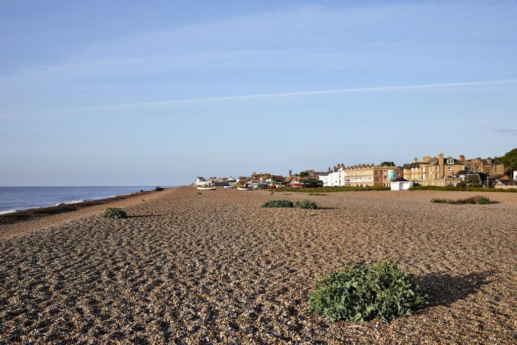 a sandy beach with houses and the ocean at Wentworth Hotel in Aldeburgh