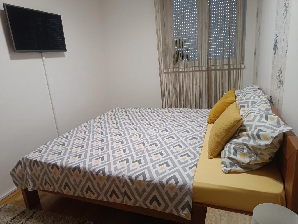 a bedroom with a bed and a television on the wall at Apartman U2 in Veliko Gradište