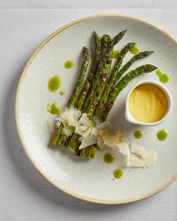 a plate of food with asparagus and a bowl of mustard at Wentworth Hotel in Aldeburgh