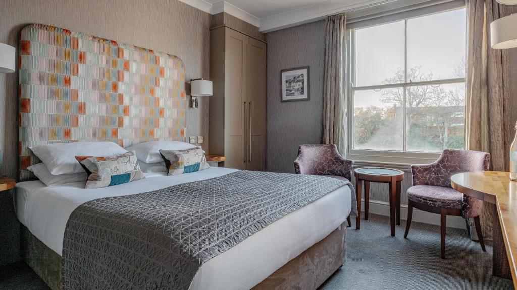 a hotel room with a bed and a window at Wentworth Hotel in Aldeburgh