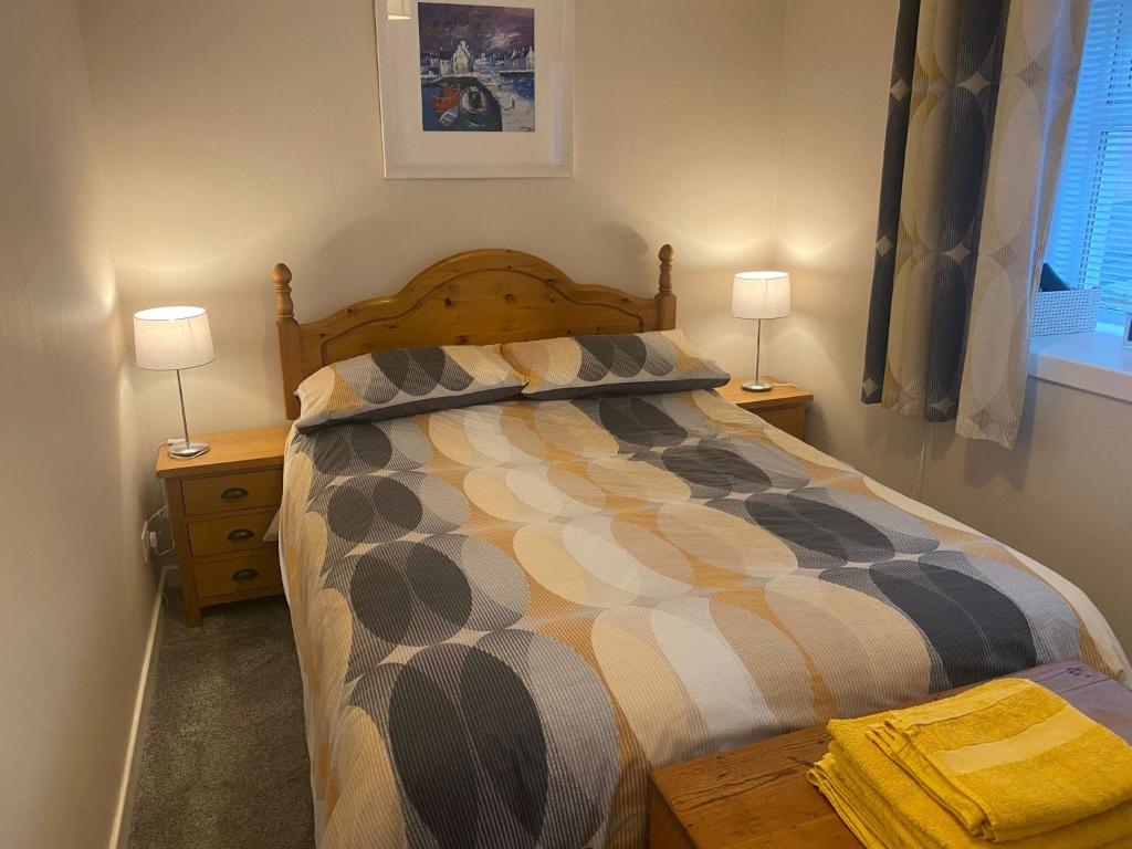 a bedroom with a bed with two night stands and two lamps at Seaview in Lossiemouth