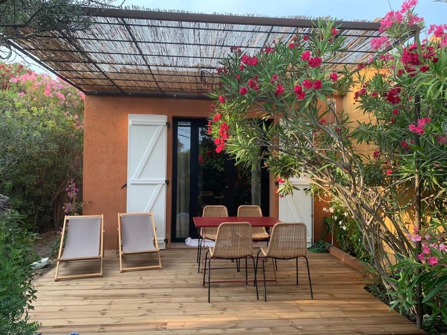 - une terrasse avec une table, des chaises et des fleurs dans l'établissement Petite maison cocooning à Bormes les mimosas, à Bormes-les-Mimosas