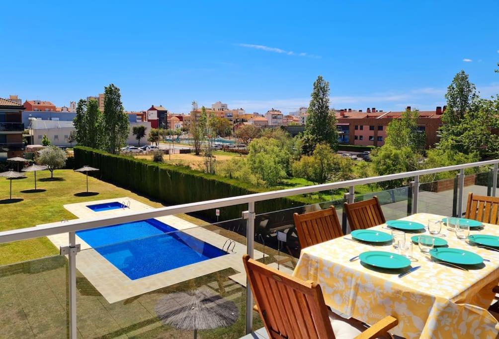 Un balcón con mesa y sillas y una piscina. en Apartamento nuevo en Sant Antoni de Calonge, en Sant Antoni de Calonge