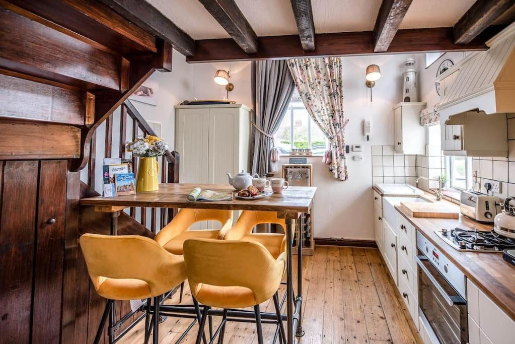 a kitchen with a table and chairs in it at The Black House, Wangford in Beccles