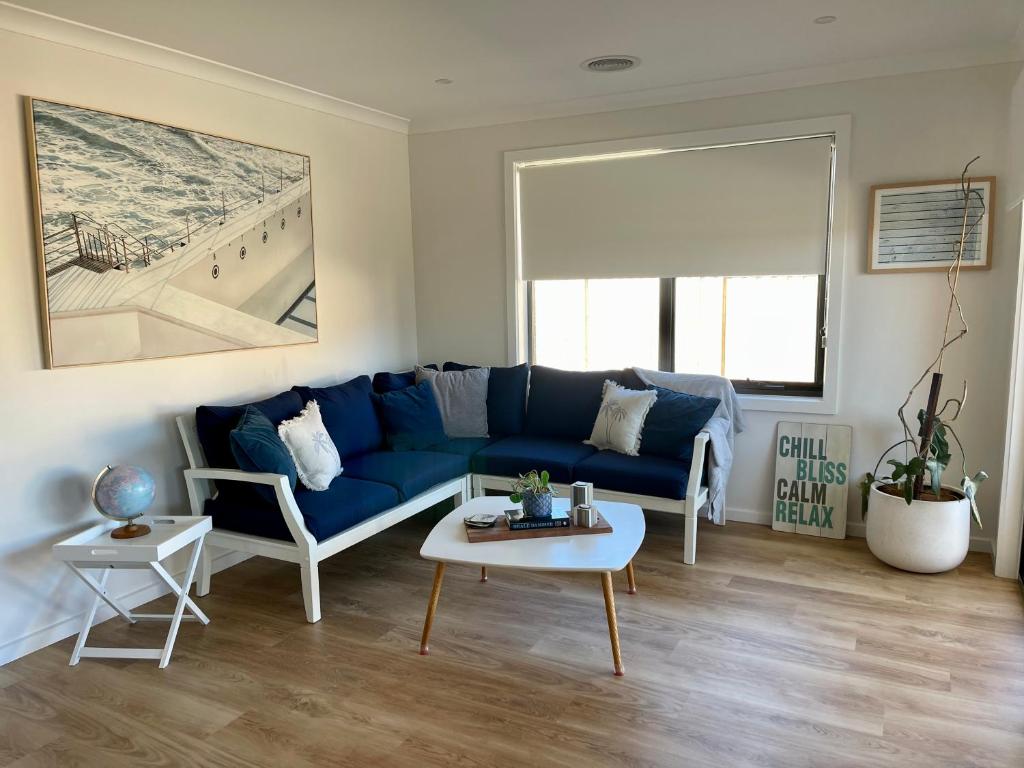 uma sala de estar com um sofá azul e uma mesa em Motion Place - Mt Duneed - Geelong, Surf Coast & Great Ocean Road em Mount Duneed