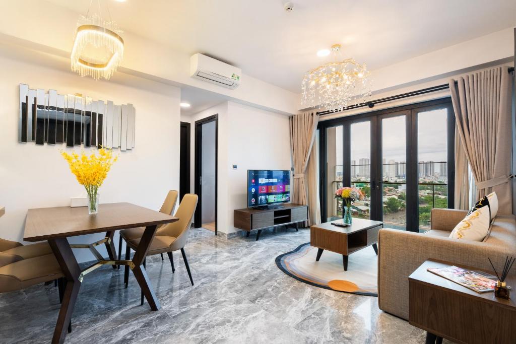 een woonkamer met een bank, een tafel en een tv bij Luxury Gold Apartment 86 : D1- Mension , Rooftop Pool - District 1 in Ho Chi Minh-stad