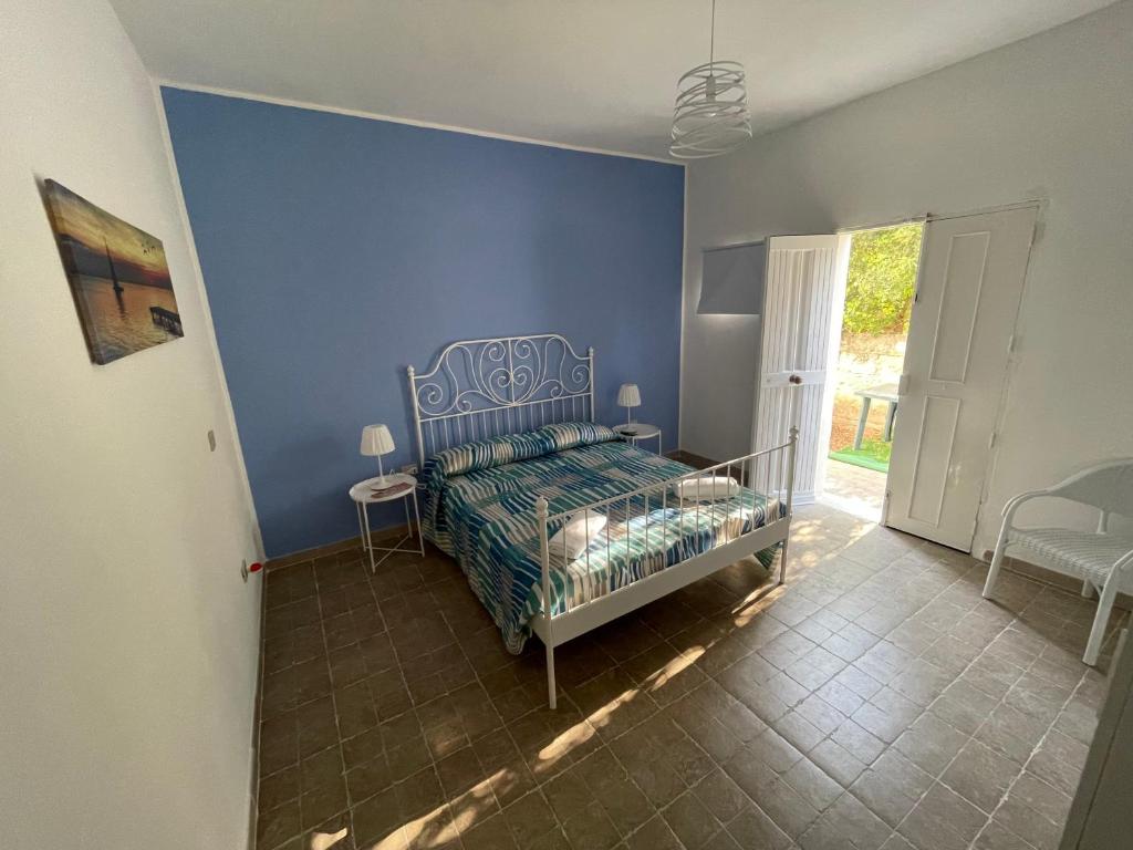 una camera da letto con un letto e una parete blu di VENTO IN POPPA a Plemmirio
