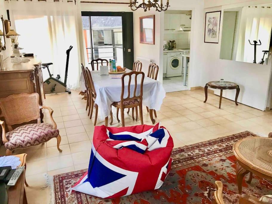 un salon avec une table et une chaise rouge dans l'établissement Grand duplex familial au cœur de Perros-Guirec, à Perros-Guirec