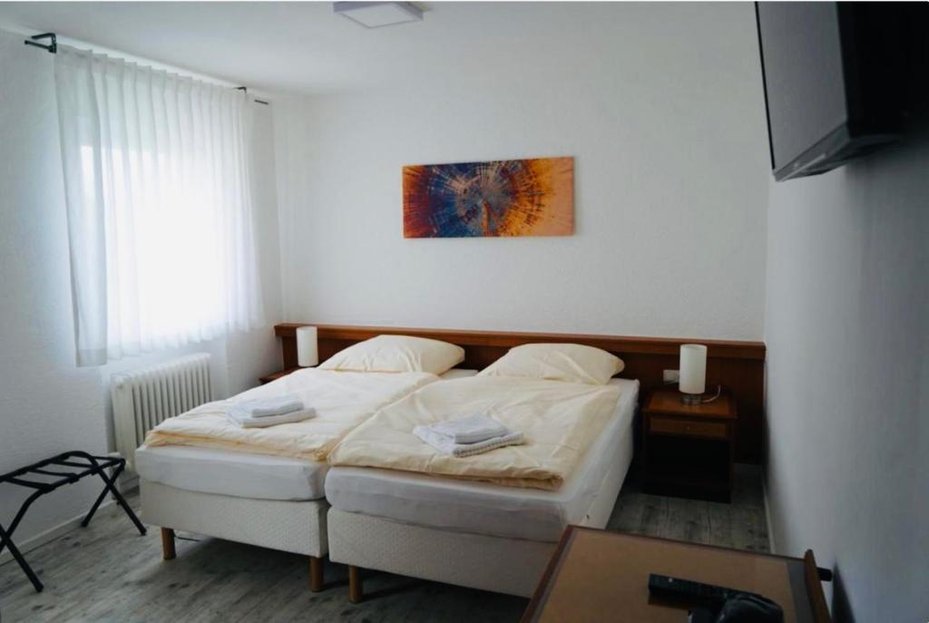 a bedroom with a bed and a table and a picture at Budget Boarding House Weidenberg in Weidenberg