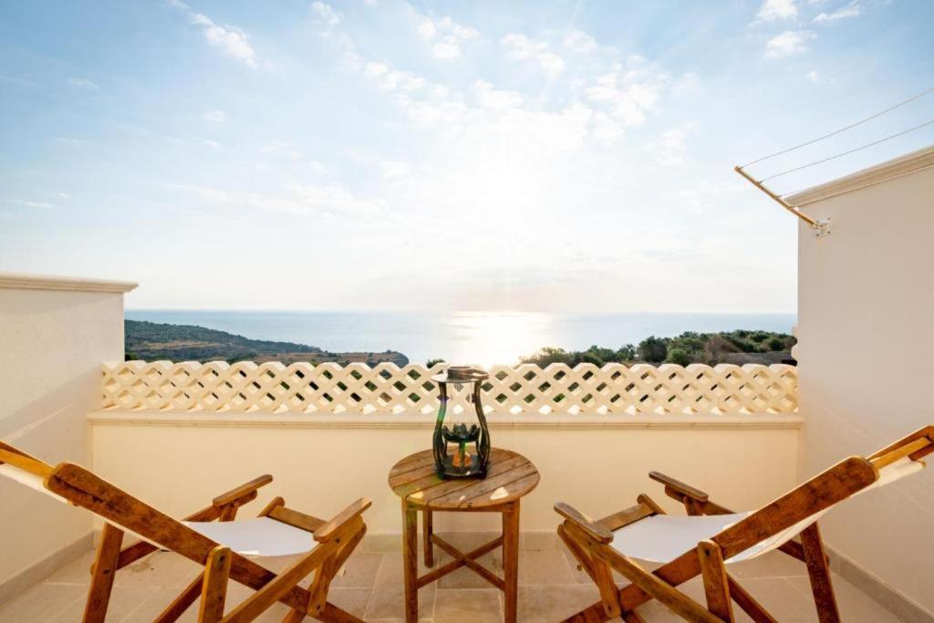 un balcón con sillas y una mesa con un jarrón. en FinisTerrae Rooms and Suites, en Gagliano del Capo