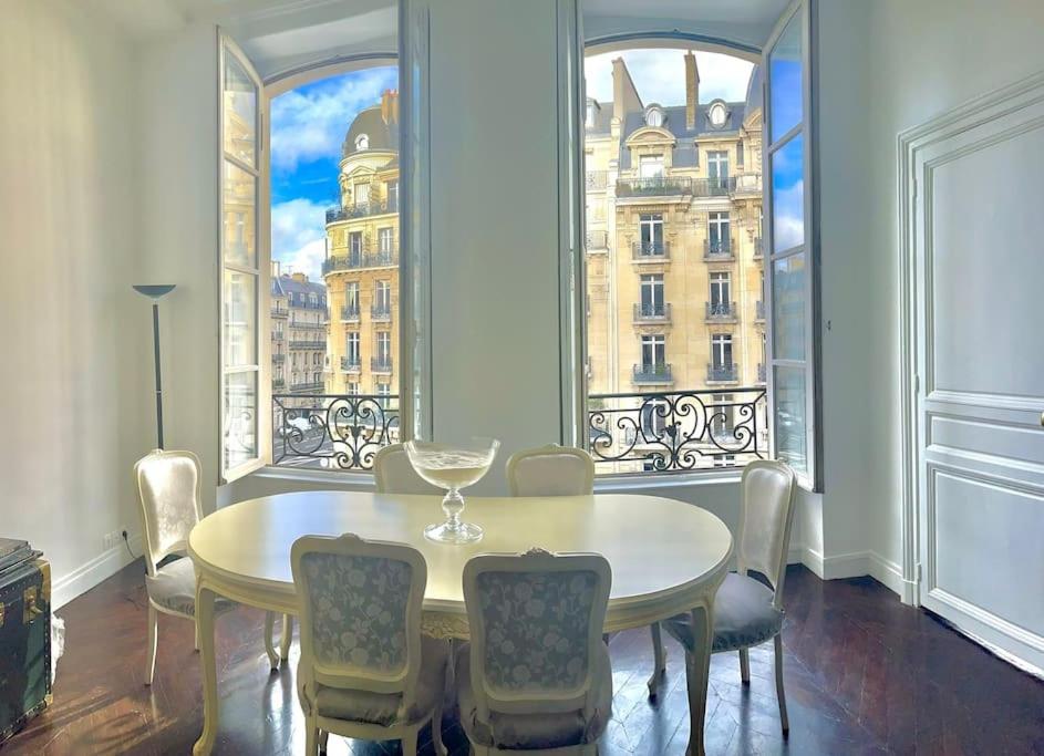 een eetkamer met een tafel en stoelen en een raam bij Exclusive Suite Parisian Palace in Parijs