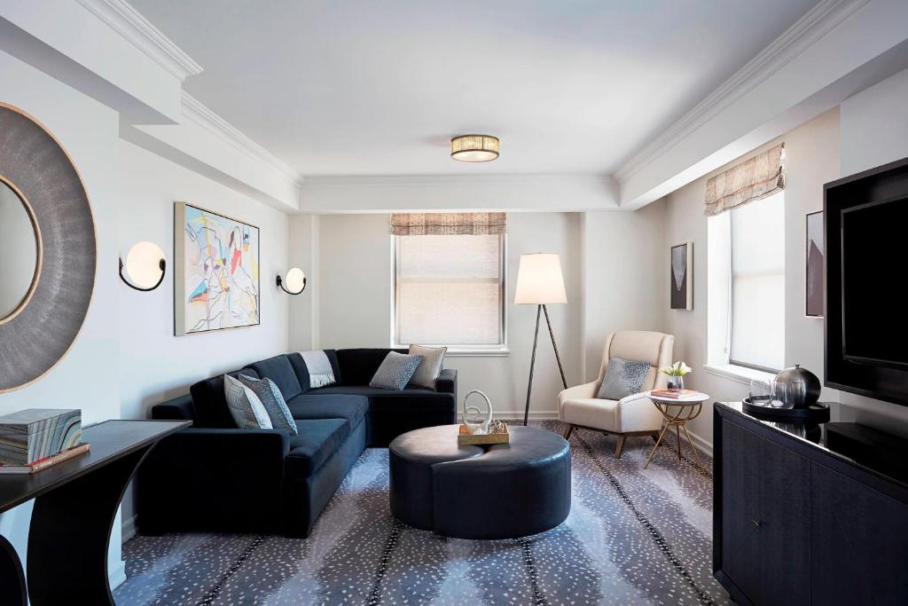 a living room with a blue couch and a tv at JW Marriott Essex House New York in New York