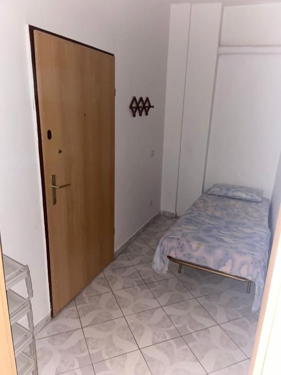 Cette petite chambre comprend un lit et une porte en bois. dans l'établissement DritaStar, à Durrës
