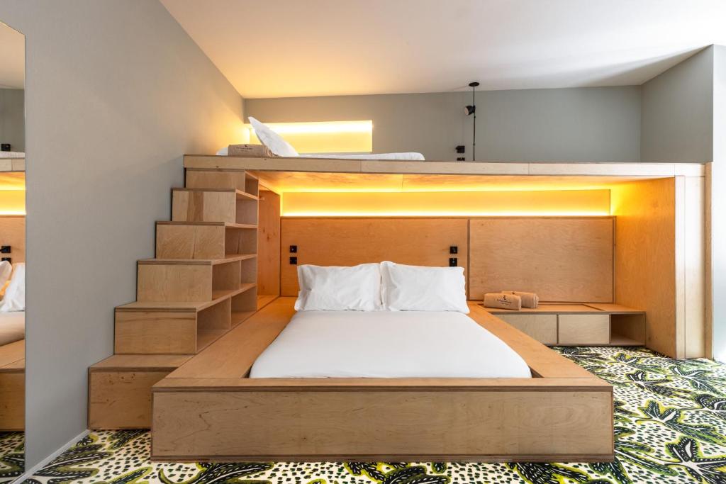 A built-in double bed beneath a raised sleeping platform, reached by integrated wooden steps.
