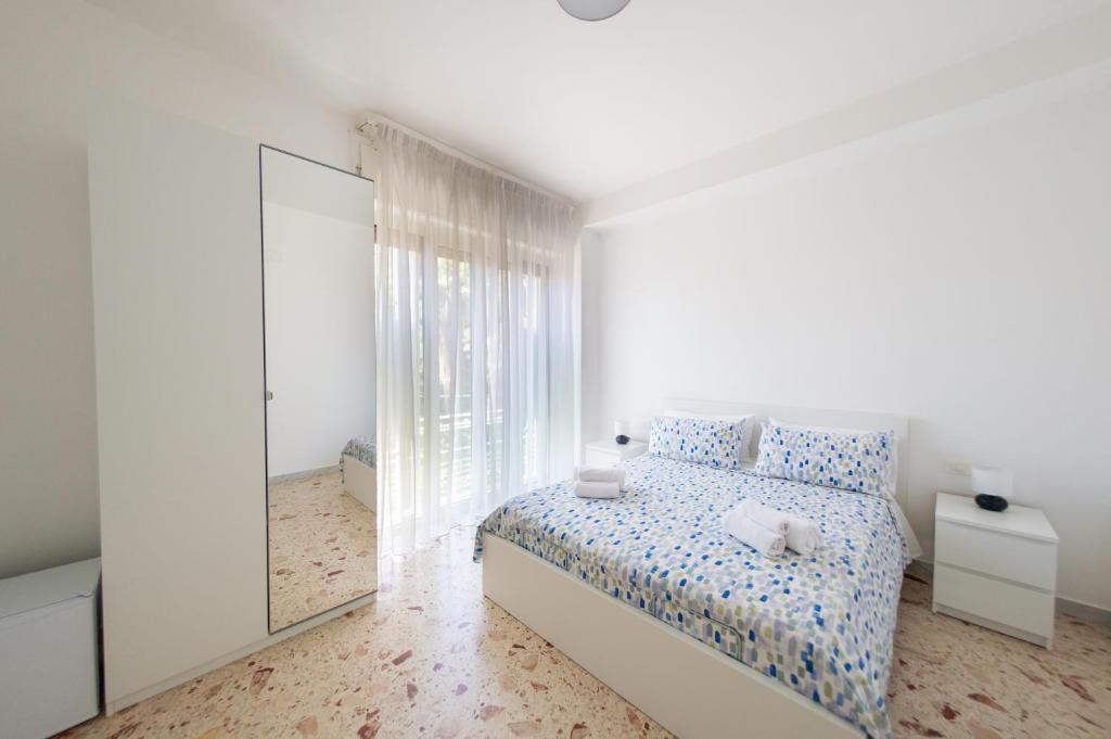 una camera da letto bianca con un letto e uno specchio di A CASA DI MARCO Salerno CENTRO a Salerno