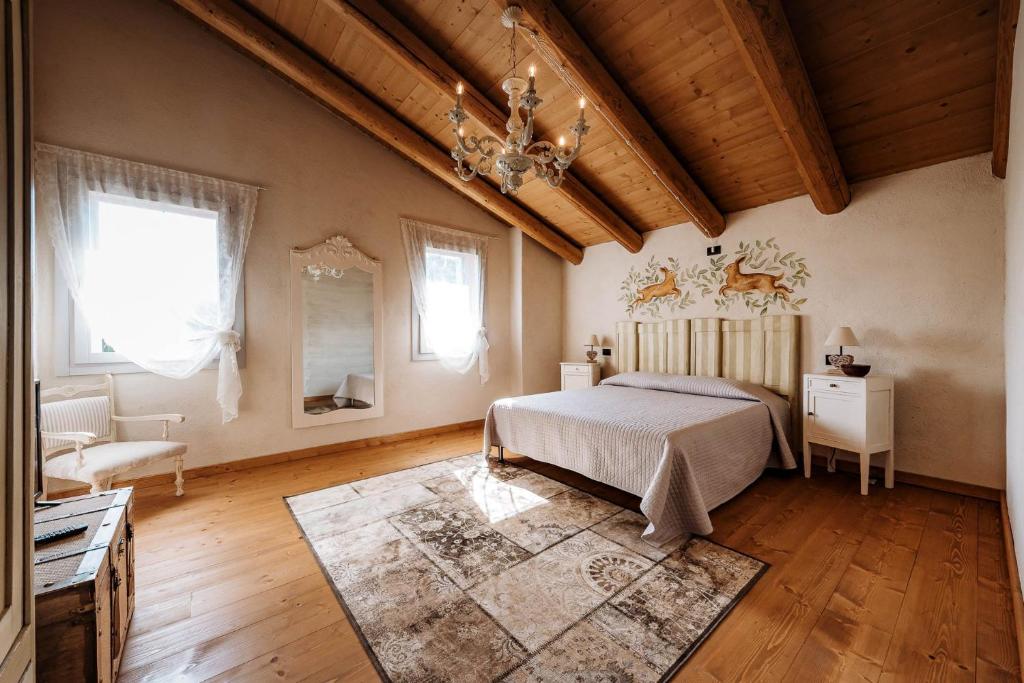 sypialnia z łóżkiem, kanapą i żyrandolem w obiekcie LOCANDA CONTA w mieście Piazzola sul Brenta