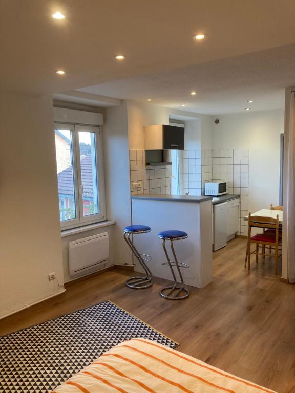 Cette chambre dispose d'une cuisine avec deux tabourets de bar. dans l'établissement Studio fonctionnel, étage 2, proche Techn'hom, IUT et UTBM, à Belfort