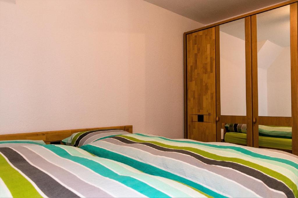 1 dormitorio con 1 cama y armario de madera en Ferienwohnung Am Berg, Eheleute Müller, en Hilchenbach