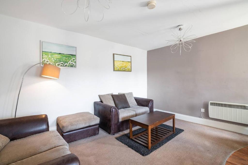 a living room with a couch and a chair and a tv at Glovers Lodge - Charming 3 Bed Retreat near City Centre in Derby
