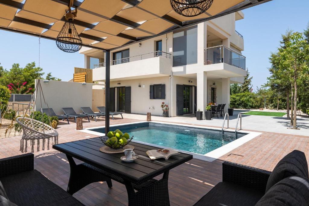een villa met een zwembad en een huis bij Dioni Pool House in Ialyssos