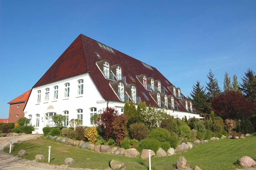 ein großes weißes Gebäude mit rotem Dach in der Unterkunft Haus Heß Ferienwohnung Nr 07 in Niendorf