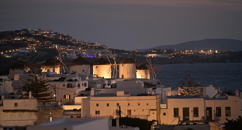 una ciudad con edificios blancos y el océano por la noche en CASA D'IRENE Mykonian residence, en Mykonos ciudad