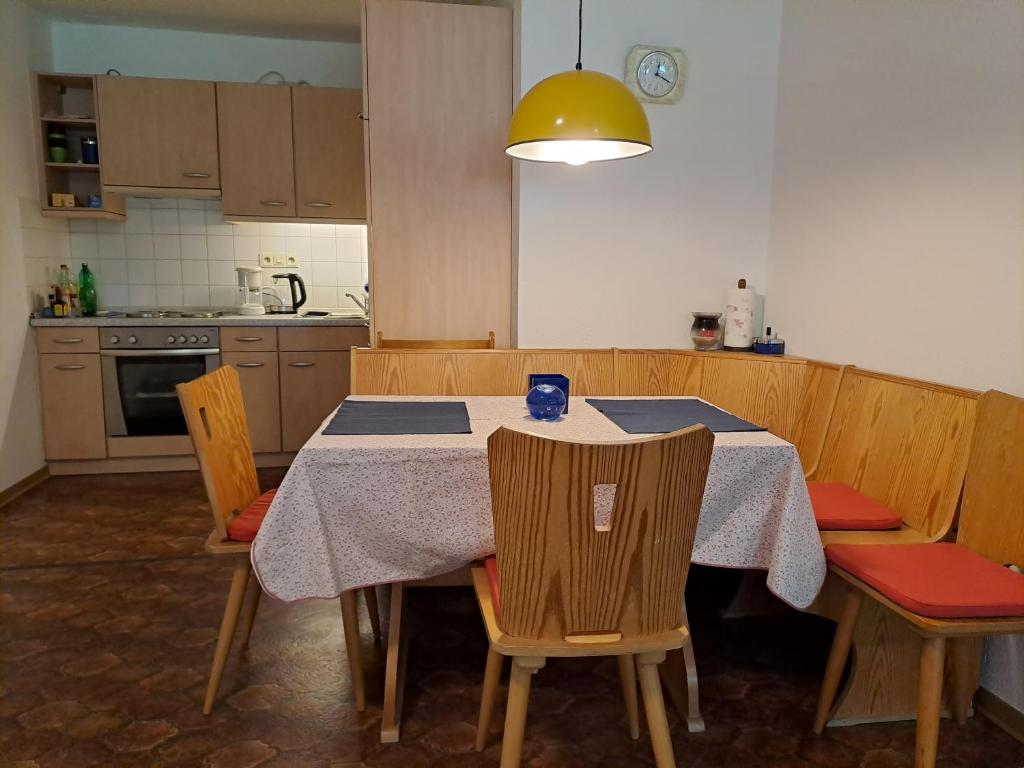 a kitchen with a table with chairs and a yellow light at Ferienwohnung Gitta 