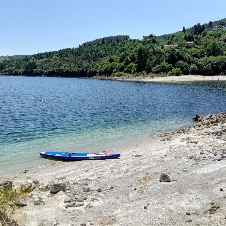 a blue boat sitting on the shore of a lake at AQUAVIEW - VENDA NOVA in Venda Nova