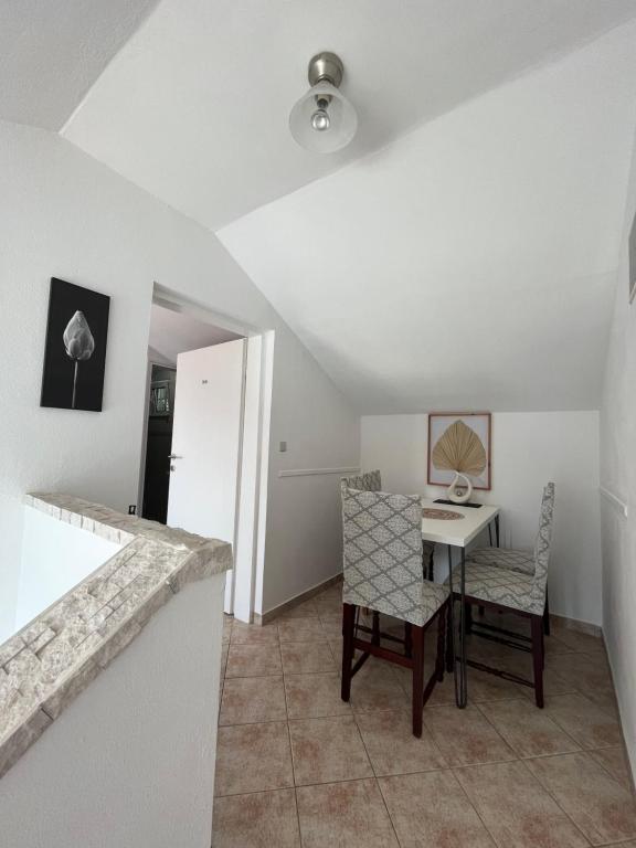 a kitchen with a table and chairs in a room at Apartmani Kalinic in Bijela