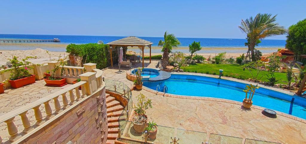 a swimming pool with a gazebo and the beach at Luxury Seafront Pool Villa - 3 Stories & Roof floor - All Master Bedrooms in Hurghada