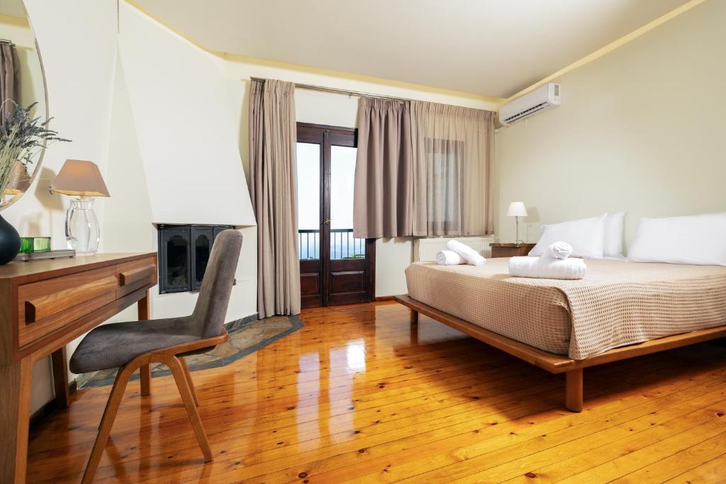 a bedroom with a bed and a desk and a chair at Dohos Hotel in Karítsa