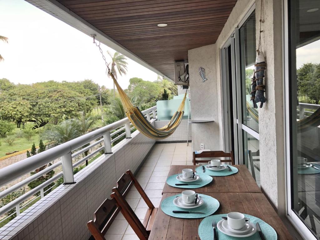 balcón con mesa, sillas y hamaca en Blue Marlin Cotovelo - Vista Vale - Reformado, en Parnamirim