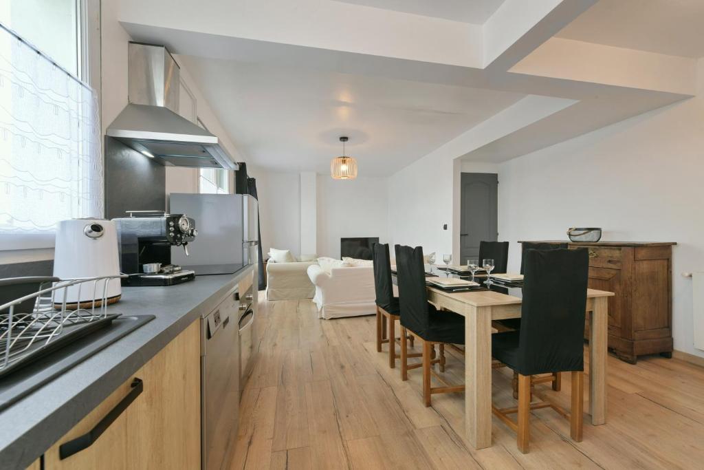 - une cuisine et une salle à manger avec une table et des chaises dans l'établissement Le Cotentin - Joli appt 2 chambres à Carentan, à Auvers