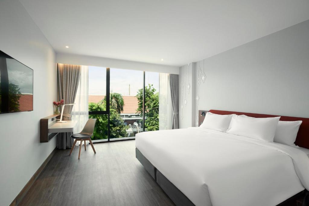 1 dormitorio con 1 cama blanca grande y escritorio en Centara Life Hotel Bangkok Phra Nakhon, en Bangkok
