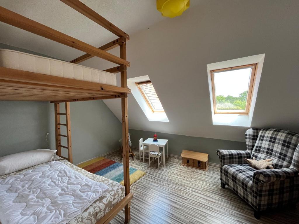 ein Schlafzimmer mit einem Etagenbett und einem Sofa in der Unterkunft Hof Langenberg in Schwanewede