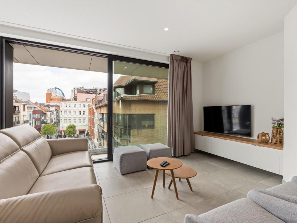 a living room with a couch and a large window at Maple Leaf 3 bedrooms on floor 3 in Blankenberge