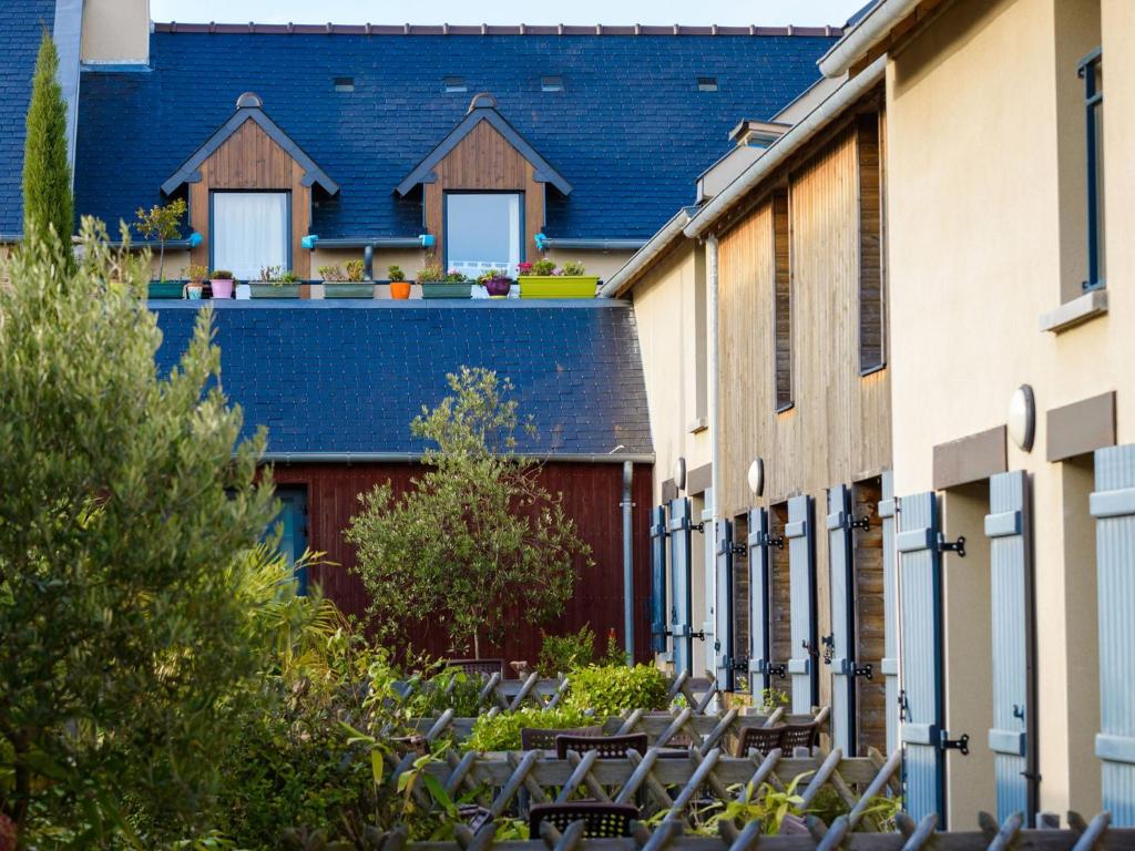 une rangée de bâtiments avec des chaises dans une cour dans l'établissement Cancale Port Family Stay, à Cancale