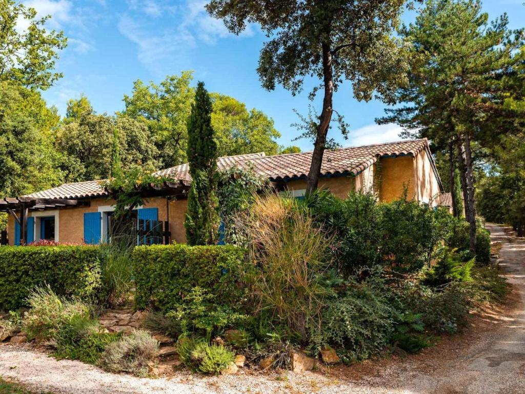 una casa antigua con un jardín delante de ella en Air-conditioned maisonette near the center of Gaujac in the Gard, en Gaujac