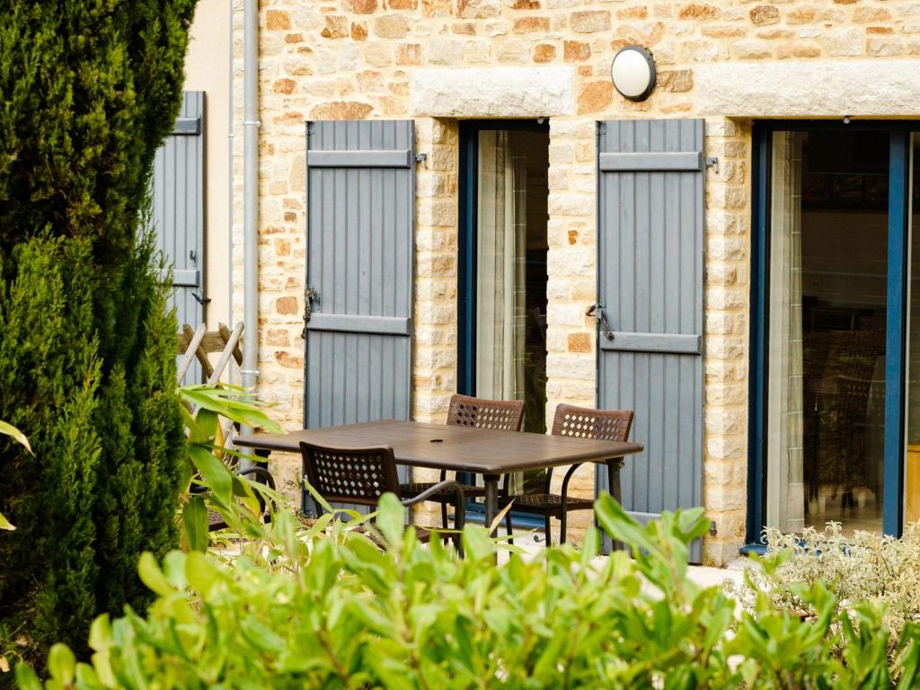un patio con tavolo e sedie di fronte a un edificio di Beautiful luxury apartment near a Breton oyster village a Cancale