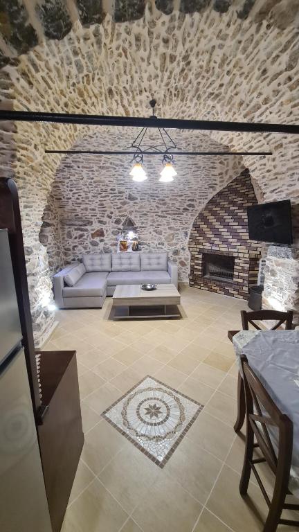 ein Wohnzimmer mit einem Sofa und einem Kamin in der Unterkunft Olympus in Olýmpoi