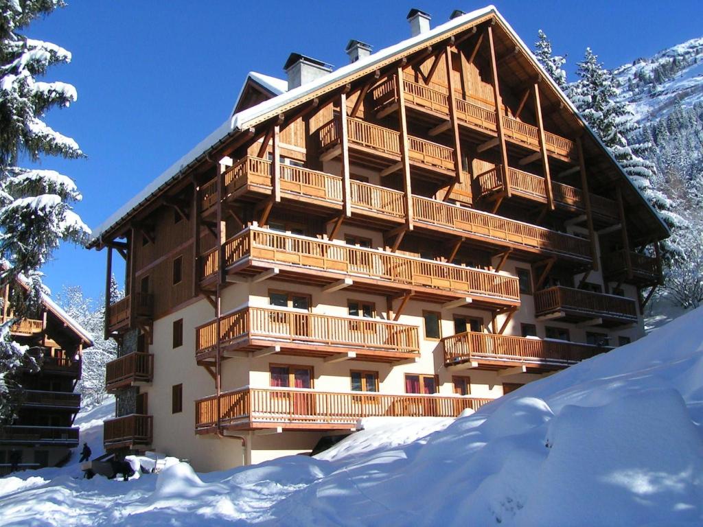 a large building with snow in front of it at Apartment on the slopes in the big ski area Grandes Rousses in Oz