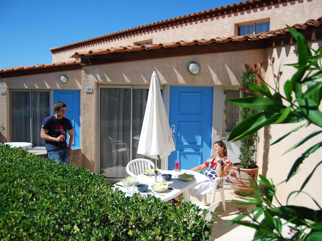 Un homme et une petite fille assis à une table dans l'établissement Villa in France with Garden and Terrace, à Saint Cyprien Plage