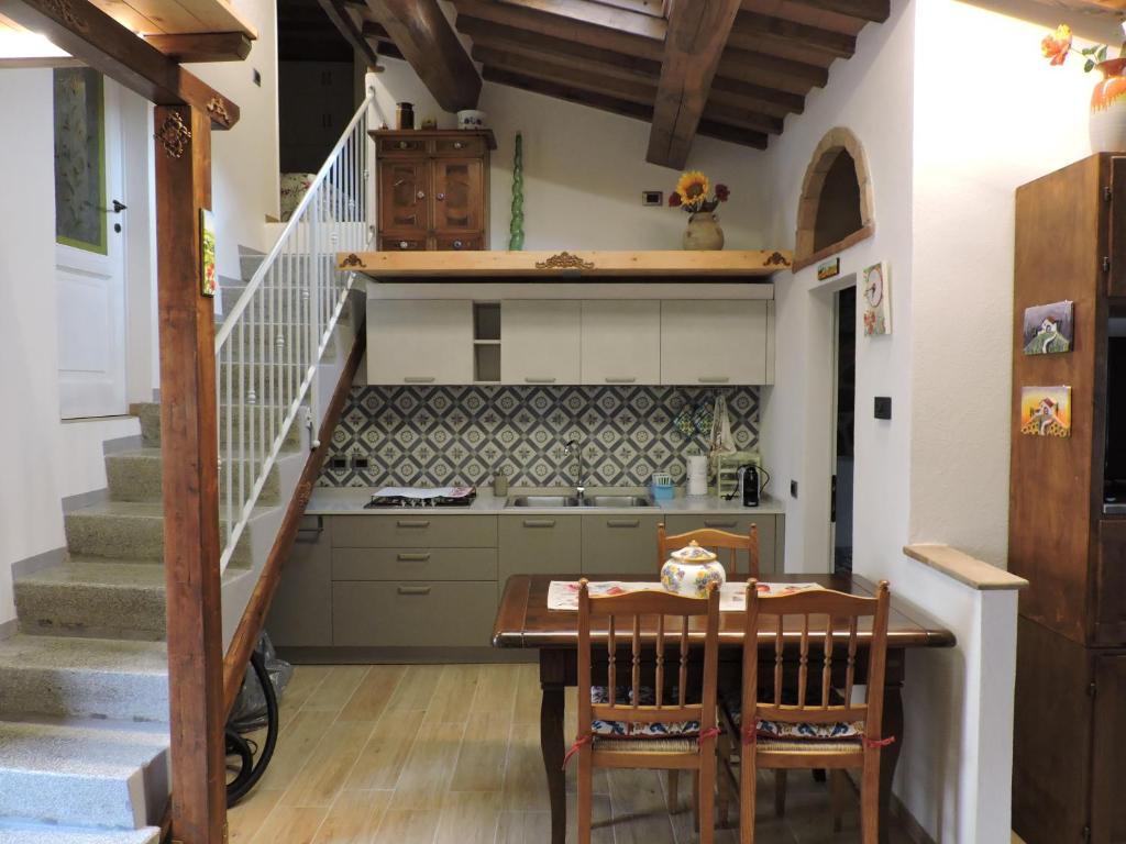 a kitchen with a table and a staircase at La Casa di Olga in Radicofani