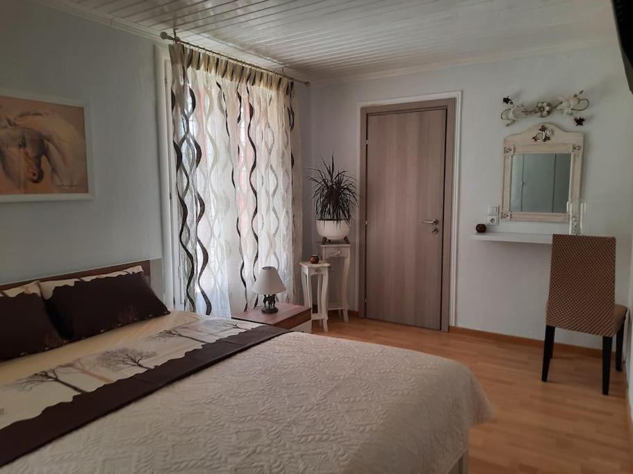 ein Schlafzimmer mit einem großen Bett und einem Fenster in der Unterkunft Casa Olena in Nea Potidaea