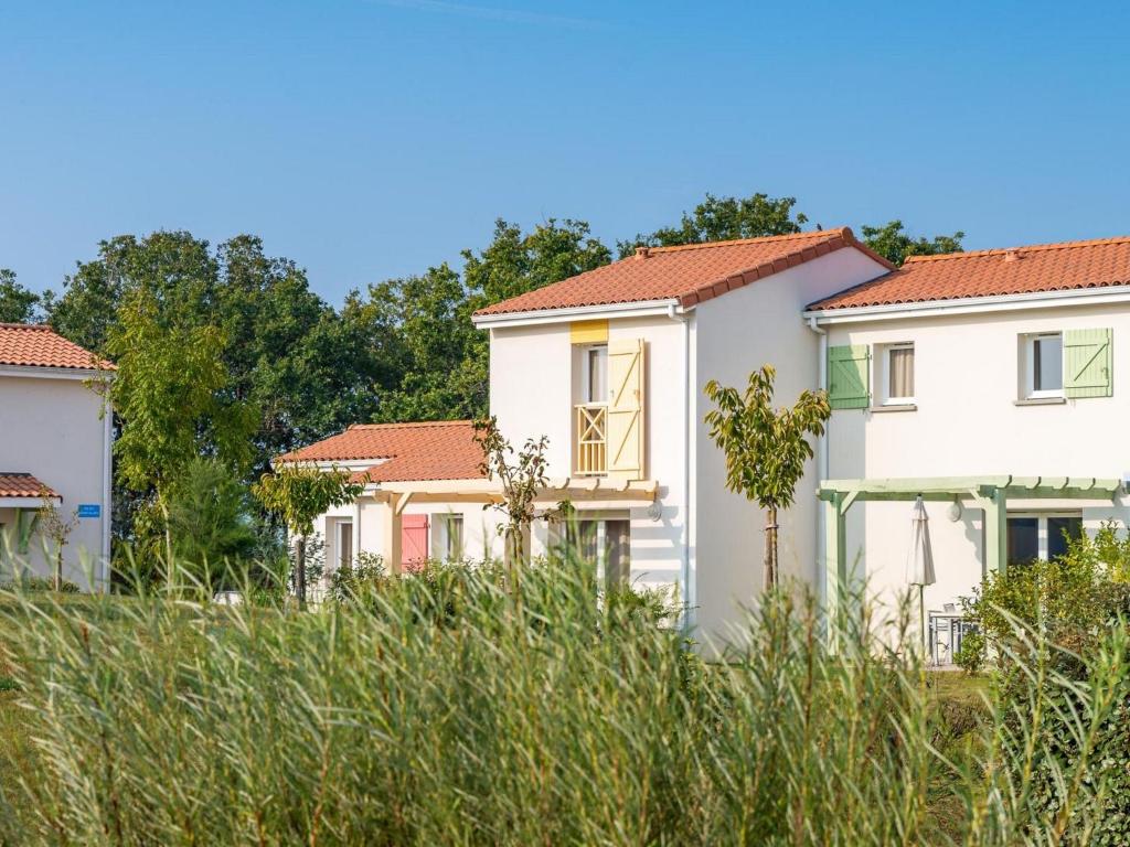Well-kept apartment, with dishwasher, 7 km from the beach في Saint-Hilaire-de-Talmont: صف من البيوت البيضاء ذات السطوح الحمراء