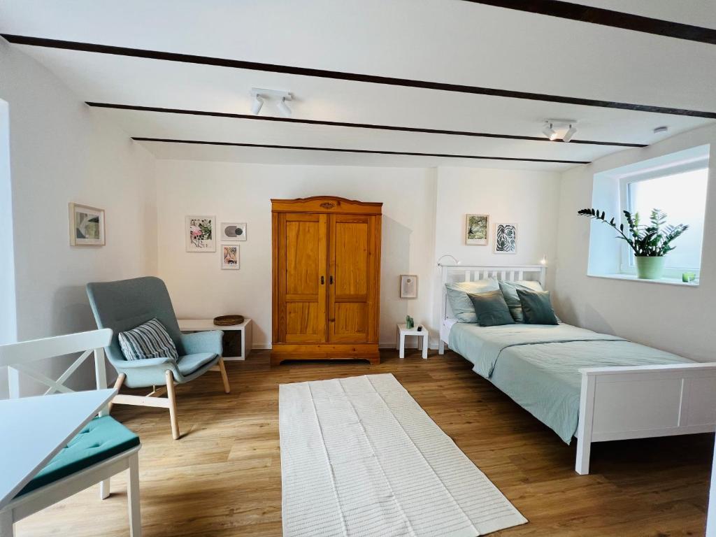 a bedroom with a bed and a couch and a chair at Restaurierter Altbau mit privatem Innenhof & Parkplatz in Großfischlingen
