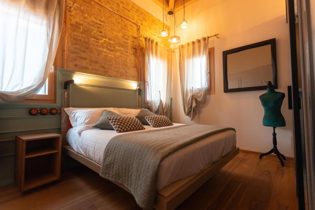a bedroom with a bed and a brick wall at Corte Lusenzo in Chioggia