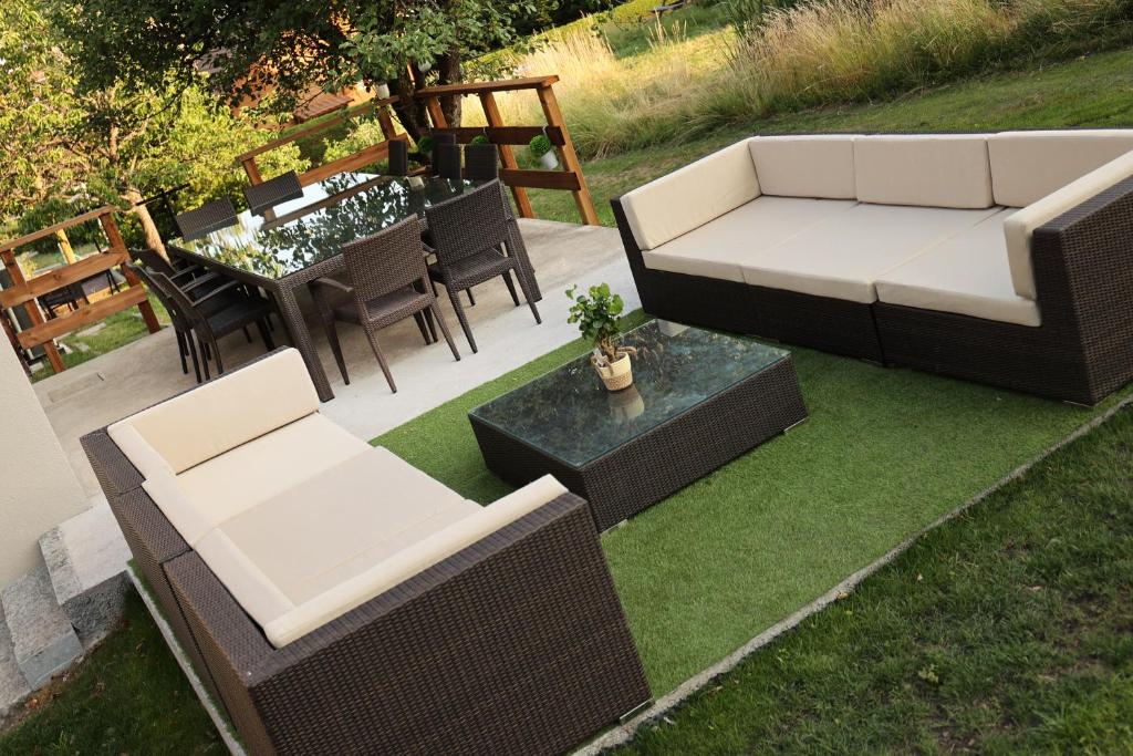 a patio with a couch and chairs and a table at Granit'Home in Gérardmer